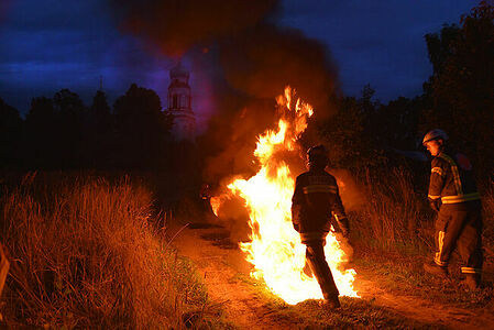 Girl firefighter goes into the fire at the exercise of the Volunteer forest firefighters