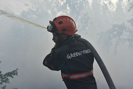 Greenpeace fireman extinguishing a peat bog