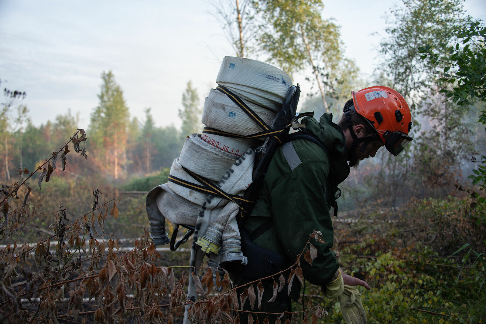 Photojournalist Anastasia Tsitsinova. Volunteer firefighters. Untitled Firefighter carries sleeves to the water